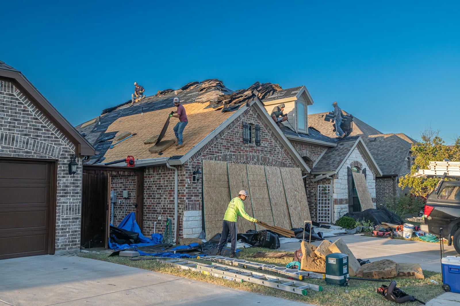 Roofing crew installing a new asphalt shingle roof on a Maryland brick home